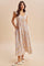 woman wearing a floral maxi dress with ruffled cap sleeves and pockets, standing on a neutral background