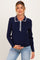 woman wearing a navy maternity sweater with decorative white buttons and collar, showcasing her baby bump