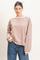 woman wearing a light brown striped long sleeve top with a relaxed fit and ribbed cuffs, paired with blue jeans