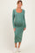 woman wearing a sage green long sleeve ribbed maternity dress with a fitted silhouette and visible baby bump