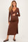 woman wearing a brown long sleeve maternity dress with a twisted front detail and showing her baby bump