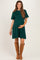 woman wearing a green maternity dress with short sleeves and holding her baby bump