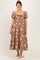 woman wearing a brown floral print maternity dress with puff sleeves and a square neckline, showing her baby bump