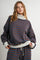 woman wearing a brown and blue striped oversized turtleneck sweatshirt with gray cuffs and matching bottom outfit