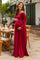 woman wearing a burgundy off-shoulder maternity dress and showing her baby bump in a garden setting