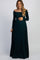 woman wearing a dark green off-the-shoulder maternity gown and holding her baby bump