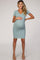 woman wearing a light blue short sleeve maternity dress and holding her baby bump