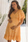 woman wearing a yellow floral maternity dress, holding her baby bump with a v-neckline and flutter sleeves