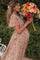 woman wearing a floral maternity maxi dress and holding a bouquet of colorful flowers, showing her baby bump
