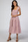 woman wearing a blush pink smocked midi dress with tie shoulder straps and tiered ruffles