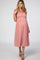woman wearing a pink smocked maternity dress with ruffled straps and a visible baby bump