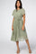 woman wearing a green floral midi dress with short sleeves and a belted waist