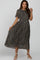 woman wearing a floral print maternity dress with short sleeves and a pleated skirt, posing and smiling