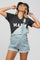 woman wearing a gray maternity t-shirt that says "mama" paired with denim overalls and a black bucket hat