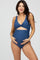 woman wearing a navy blue maternity swimsuit with a cutout detail and holding her baby bump