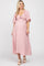 woman wearing a light pink maternity dress with a tie front and flutter sleeves, showing her baby bump