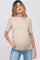 woman wearing a beige short sleeve maternity top with puff shoulders and a visible baby bump