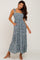 woman wearing a blue floral smocked tiered maxi dress with tie straps and pockets