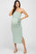 woman wearing a light green ribbed one-shoulder maternity dress with a tie at the waist and a visible baby bump