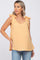 woman wearing a mustard yellow maternity tank top with bow tie straps and a visible baby bump