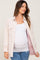 pregnant woman wearing a white maternity tank top and a light pink corduroy shacket with blue jeans