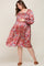 Pregnant woman in a floral smocked maternity dress with long sleeves and a square neckline