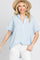 woman wearing a blue and white striped short sleeve button down shirt and straw hat