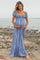 woman wearing a blue and white striped off-the-shoulder maternity dress with a baby bump at the beach