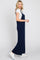 woman wearing a navy blue maxi dress with a fitted white t-shirt underneath and white sneakers