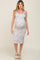woman wearing a white floral maternity dress with spaghetti straps and a visible baby bump