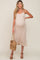 woman wearing a cream ribbed maternity midi dress with a baby bump and holding a woven bag
