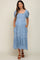 woman wearing a light blue floral maternity dress with puff sleeves and pockets, showcasing her baby bump