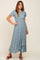 woman wearing a light blue floral print wrap maxi dress with short sleeves and brown platform sandals