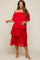 woman wearing a red off-the-shoulder maternity dress with tiered pleats and holding her baby bump