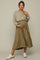 pregnant woman wearing olive green pleated maternity midi skirt and tan long sleeve henley top