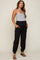 woman wearing a gray tank top and black maternity cargo pants with pockets and elastic cuffs, showcasing her baby bump