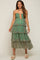 woman wearing a green floral tiered maternity midi dress with orange lace-up bodice and smocked detailing