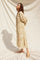 woman wearing a loose-fitting beige patterned maxi dress with long sleeves and side slits
