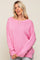 woman wearing a oversized pink knitted sweater with a wide neckline and side slits