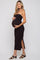 woman wearing a black ribbed maternity dress with a side slit and holding her baby bump