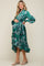 woman wearing a green floral wrap maternity dress with ruffled hem and a visible baby bump