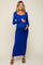 woman wearing a long sleeve blue maternity maxi dress and gently holding her baby bump