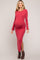 woman wearing a red ribbed maternity dress with long sleeves and side slit, showing her baby bump