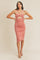 woman wearing a coral ruched bodycon dress with a cut-out detail and crisscross straps