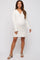 woman wearing a cream knitted maternity dress with a v-neck and long sleeves, showing her baby bump