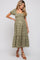 woman wearing a green and white checkered maternity dress with puff sleeves and a tiered hem