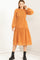 woman wearing an orange long sleeve smocked dress with a flowy skirt and black ankle boots