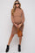 woman wearing a brown ribbed maternity dress with long sleeves and a fitted silhouette, holding her baby bump
