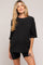 woman wearing a black ribbed maternity top and matching shorts, showing her baby bump