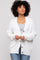 woman wearing a white oversized cardigan with wooden buttons over a gray top and blue jeans
